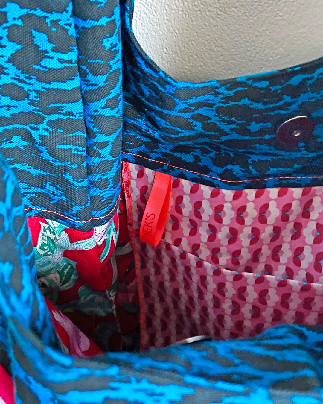unieke, handgemaakte en kleurrijke hobobag van PIEKS creations met blokjespatroon in zwart met rood en roze sierband - binnenkant