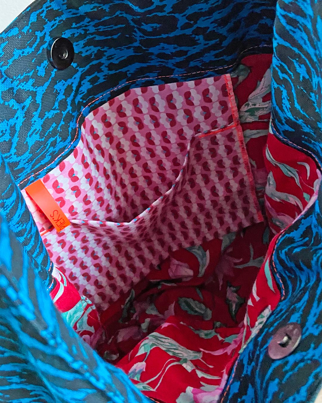 unieke, handgemaakte en kleurrijke hobobag van PIEKS creations met blokjespatroon in zwart met rood en roze sierband - rode binnenkant