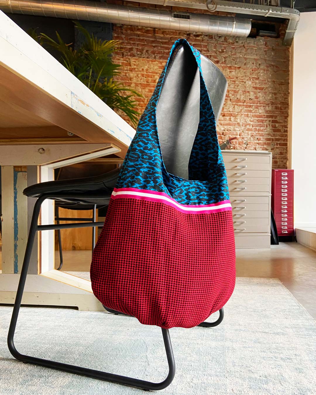 unieke, handgemaakte en kleurrijke hobobag van PIEKS creations met blokjespatroon in zwart met rood en roze sierband - sfeerfoto