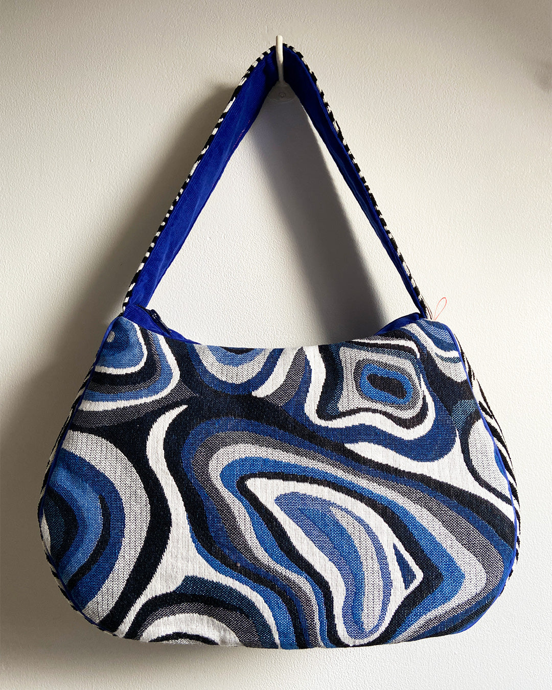 unieke, handgemaakte en stijlvolle schoudertas van PIEKS creations met grafisch patroon in zwart, wit en blauw en zebraprint aan de zijkant - achterkant