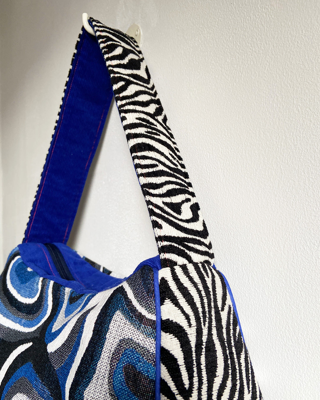 unieke, handgemaakte en stijlvolle schoudertas van PIEKS creations met grafisch patroon in zwart, wit en blauw en zebraprint aan de zijkant - close up