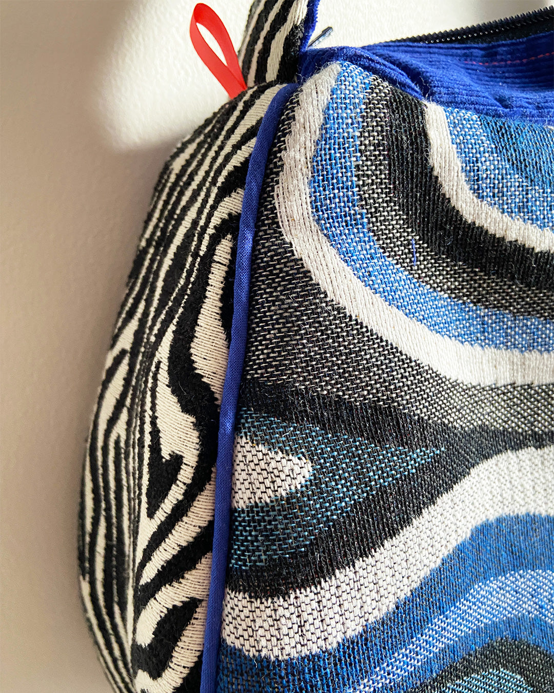 unieke, handgemaakte en stijlvolle schoudertas van PIEKS creations met grafisch patroon in zwart, wit en blauw en zebraprint aan de zijkant - detail van blauwe piping