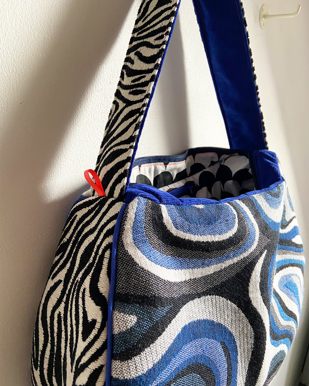 unieke, handgemaakte en stijlvolle schoudertas van PIEKS creations met grafisch patroon in zwart, wit en blauw en zebraprint aan de zijkant - open tas