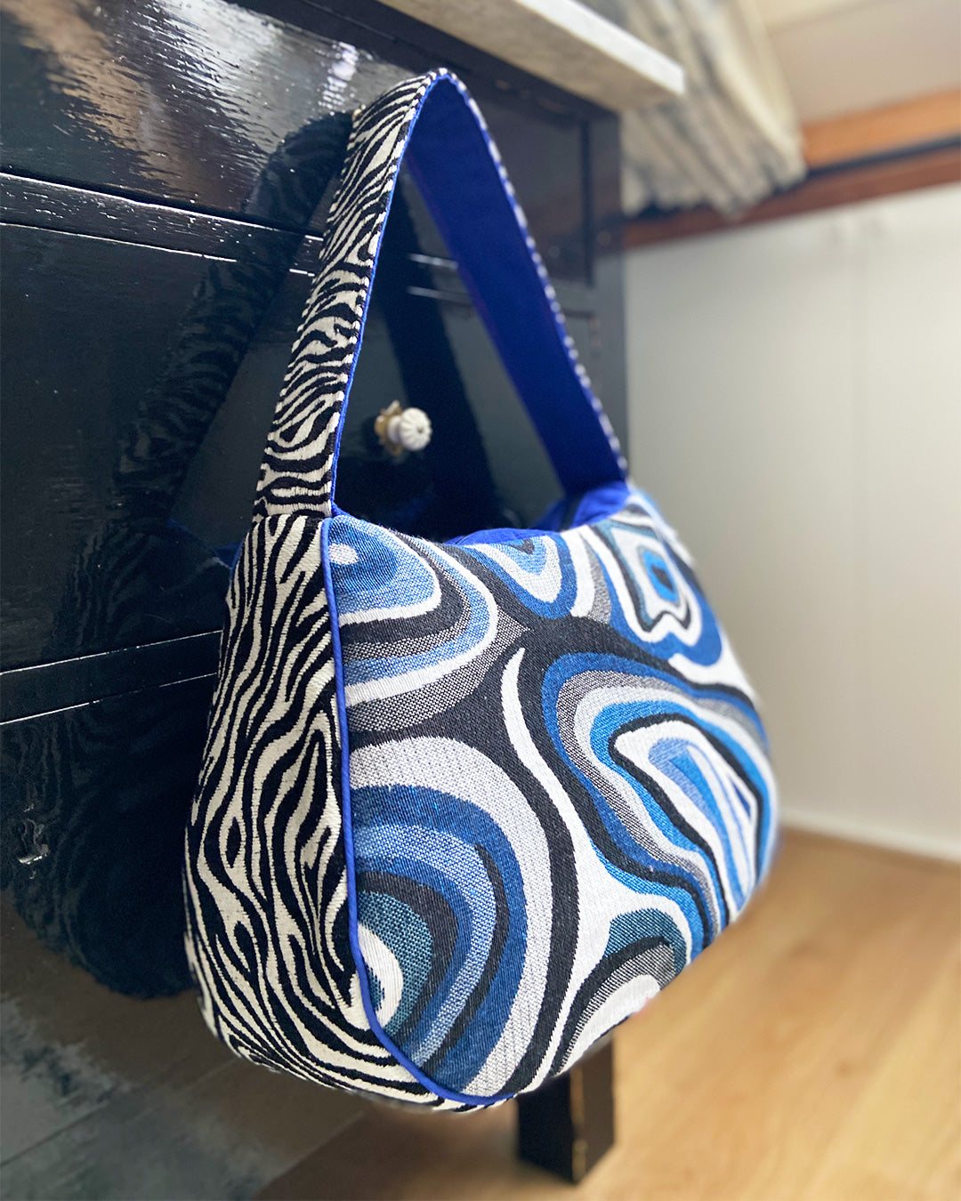 unieke, handgemaakte en stijlvolle schoudertas van PIEKS creations met grafisch patroon in zwart, wit en blauw en zebraprint aan de zijkant - sfeerfoto