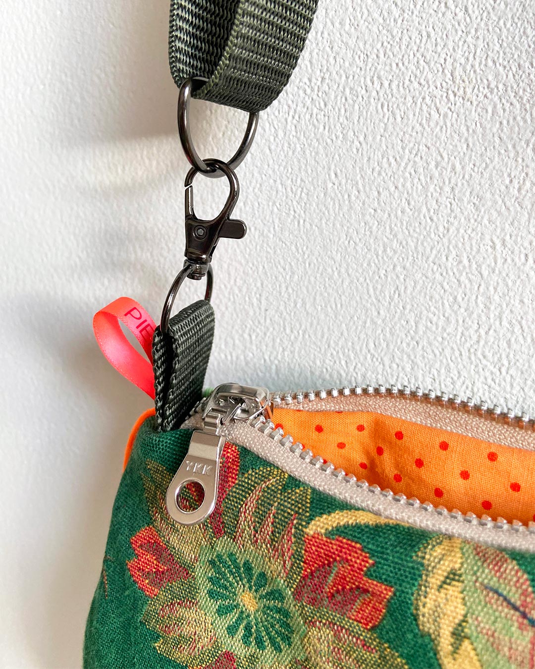 uniek, handgemaakt en kleurrijk handtasje van PIEKS creations groen met bloemen en streepjes en oranje accent - detail rits