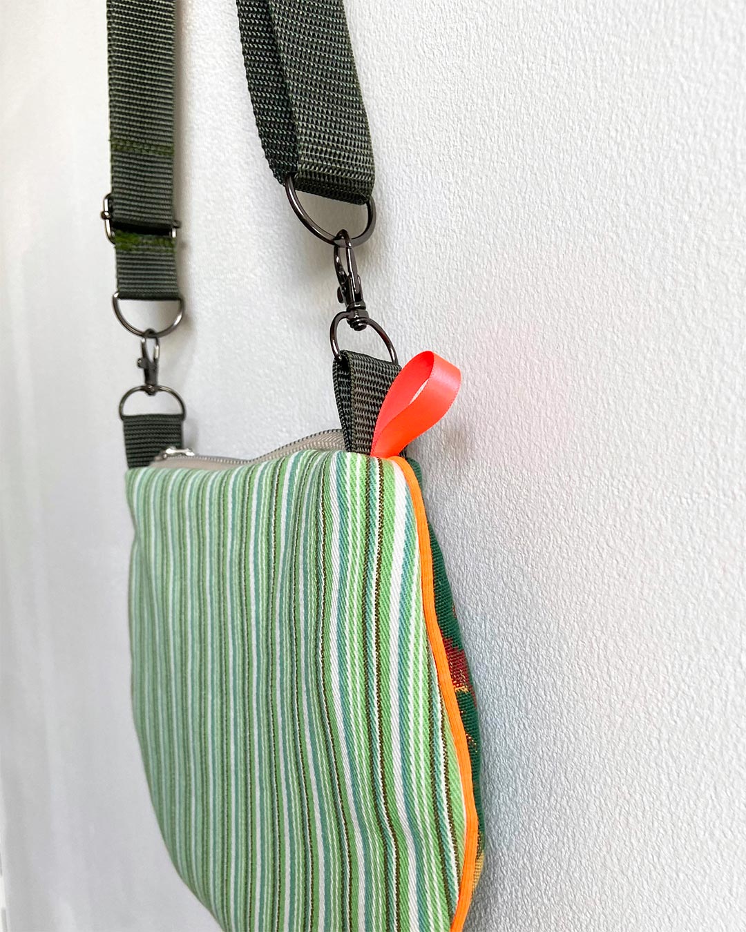 uniek, handgemaakt en kleurrijk handtasje van PIEKS creations groen met bloemen en streepjes en oranje accent - zijkant met strepen
