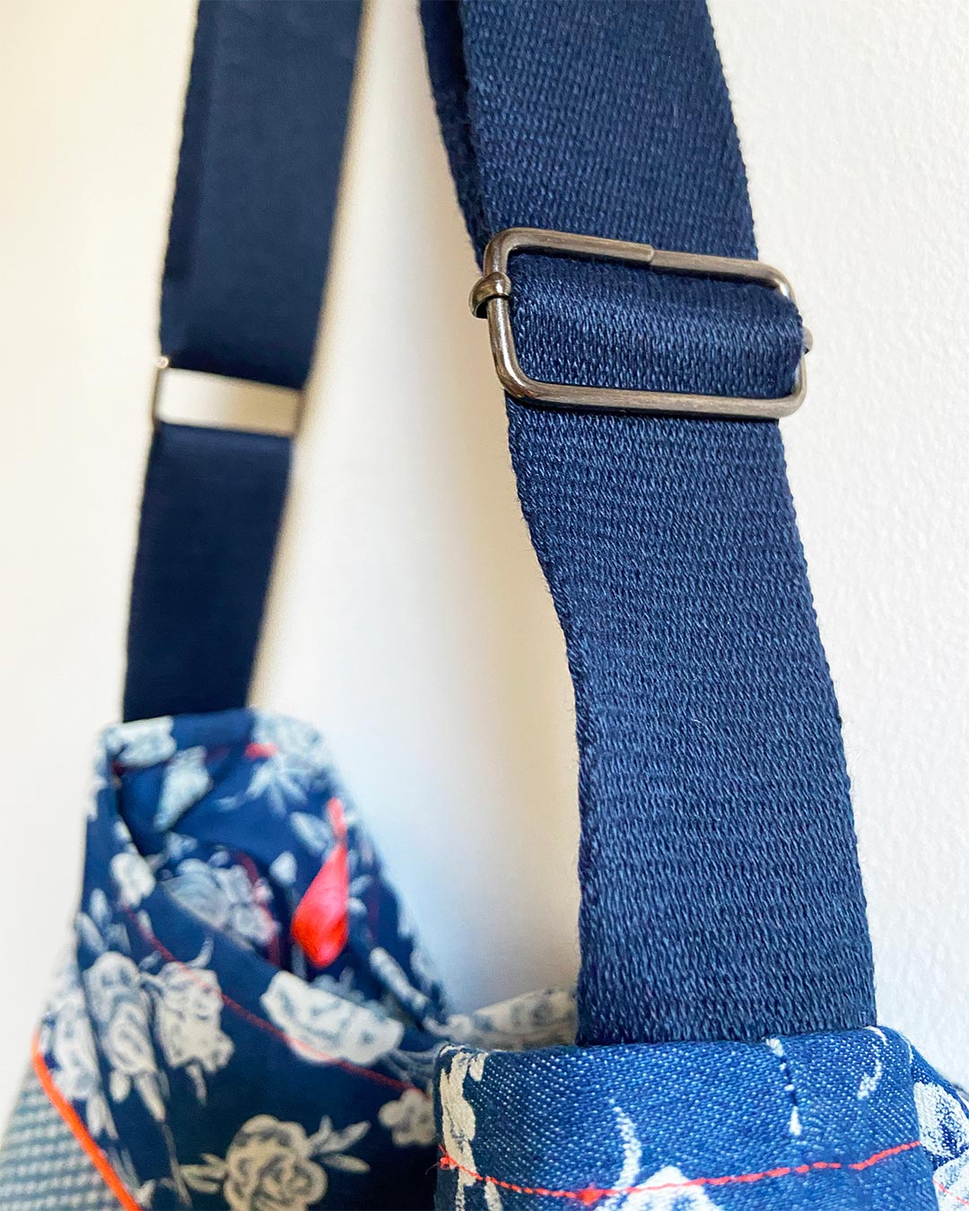 unieke, handgemaakte en stijlvolle crossbody bag van PIEKS creations in blauw met bloemen en oranje accent - schouderband