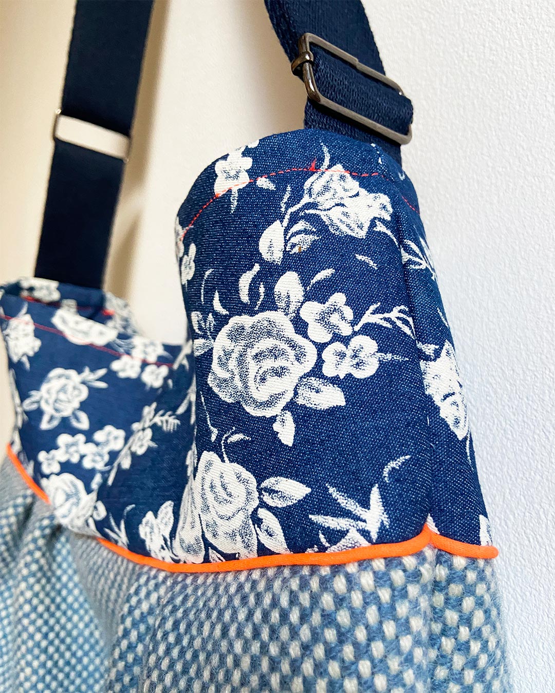 unieke, handgemaakte en stijlvolle crossbody bag van PIEKS creations in blauw met bloemen en oranje accent - zijkant