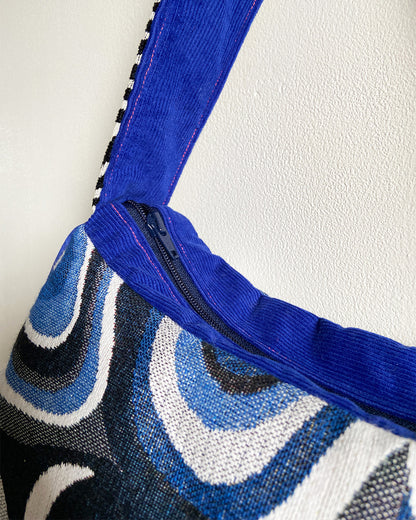 unieke, handgemaakte en stijlvolle schoudertas van PIEKS creations met grafisch patroon in zwart, wit en blauw en kobalt blauwe babyrib als afwerking - rits