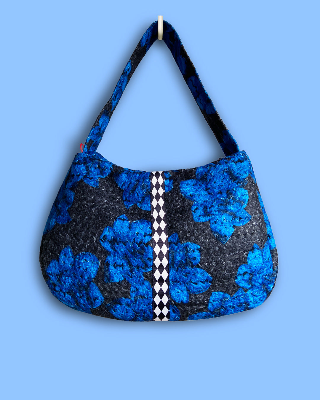 unieke, handgemaakte en stijlvolle wollen schoudertas van PIEKS creations in zwart met grote donkerblauwe bloemen en een stoere band met een grafisch zwart wit ruit  - voorkant