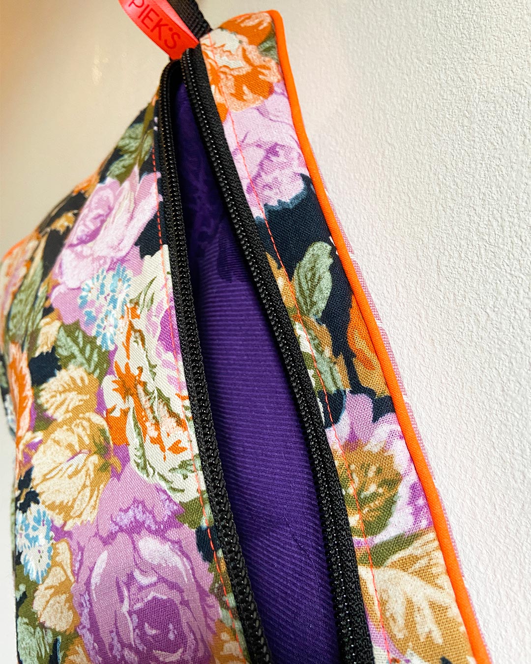 unieke tas en handige bag-in-bag van PIEKScreations met oranje en paarse bloemen op een zwarte ondergrond - paarse binnenkant