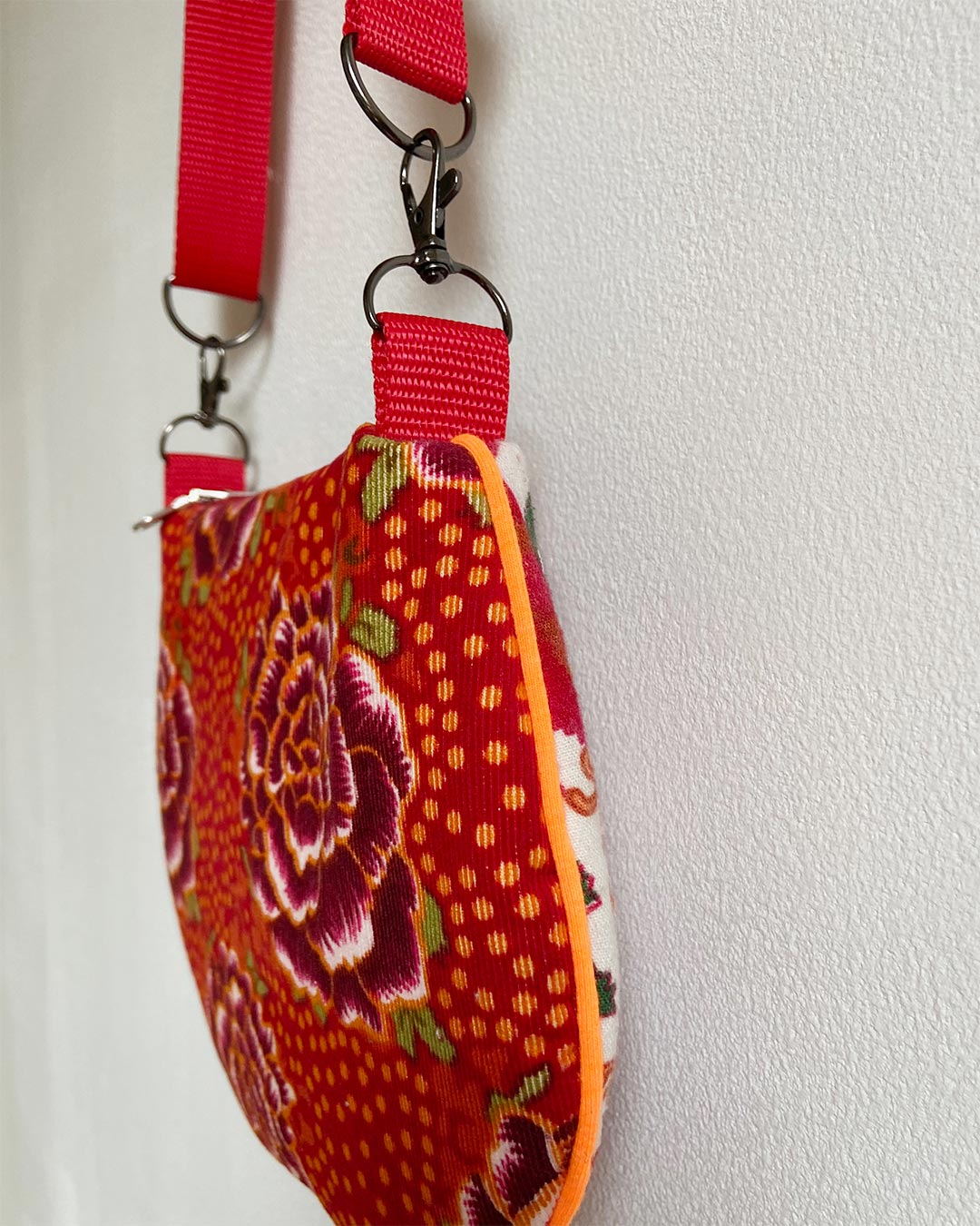 uniek, handgemaakt en kleurrijk handtasje van PIEKS creations met bloemenpatroon in oranje kleuren - zijkant