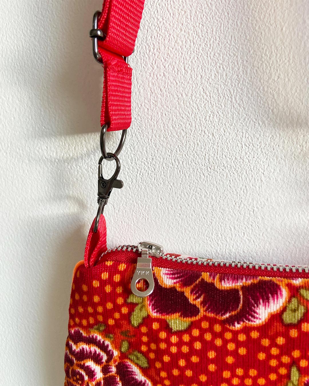 uniek, handgemaakt en kleurrijk handtasje van PIEKS creations met bloemenpatroon in oranje kleuren - schouderband