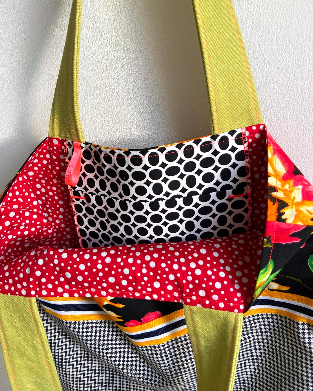 unieke, handgemaakte en kleurrijke totebag van PIEKS creations met vrolijke bloemen en zwart wit patroon - rode binnenkant
