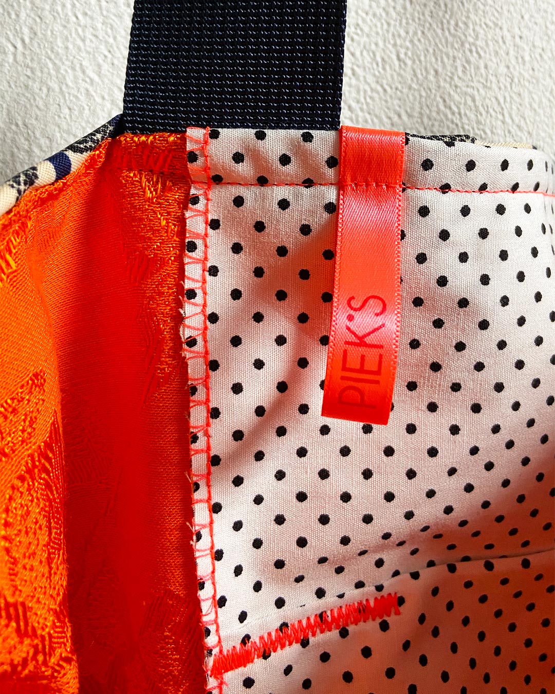 unieke, handgemaakte en kleurrijke totebag van PIEKS creations met grote bloemen en gouden details - label